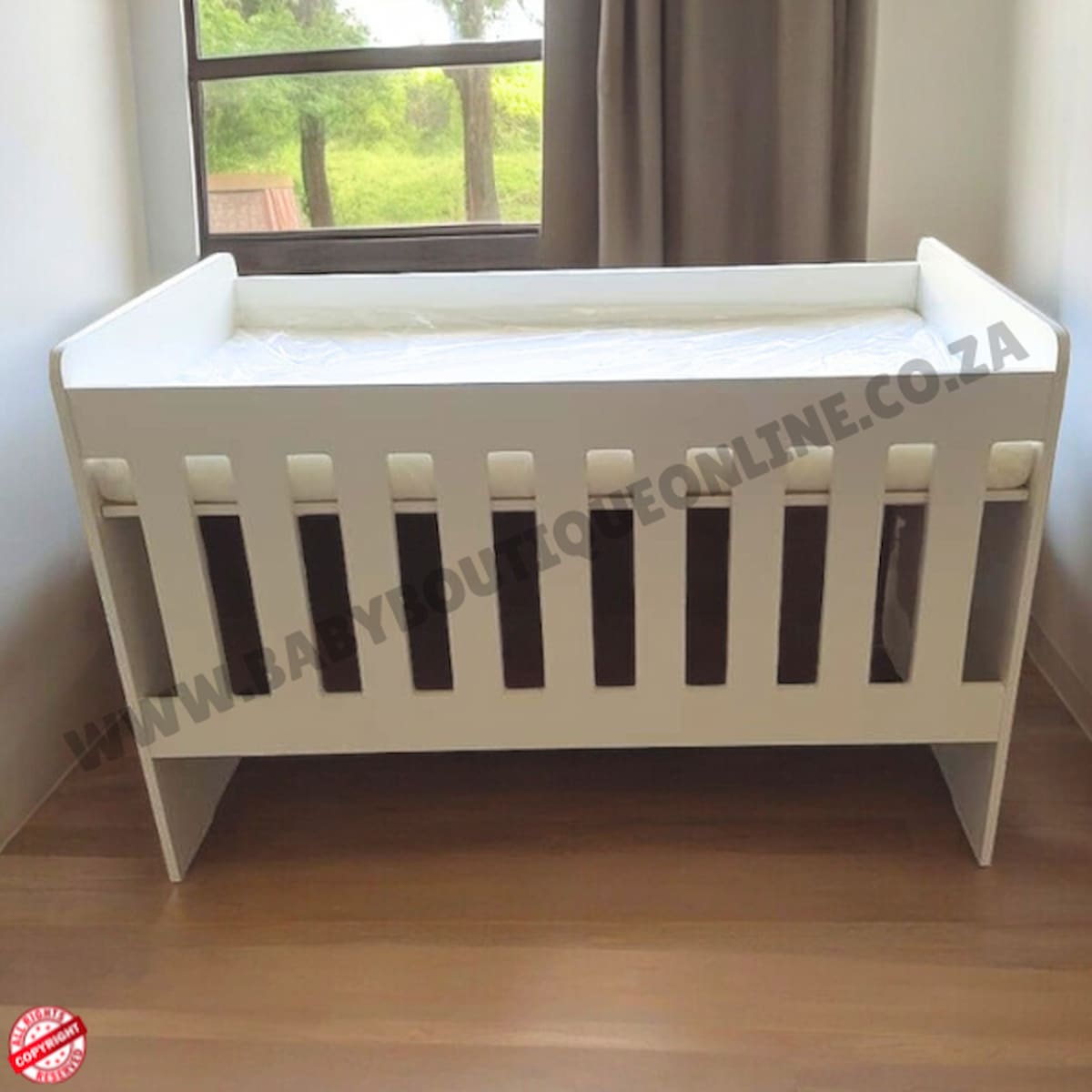 Large Wooden Cot-White crib on a wooden floor with a window in the background