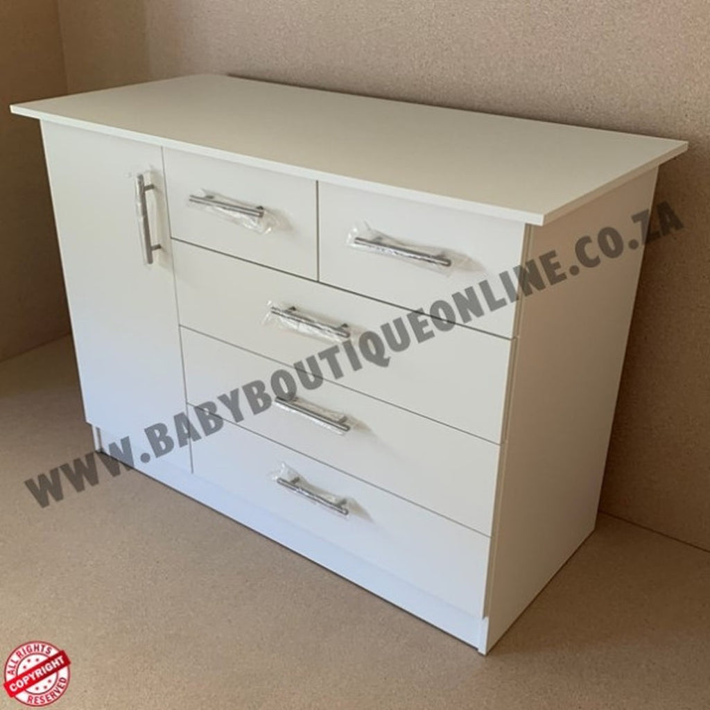 White dresser with multiple drawers against a beige wall.