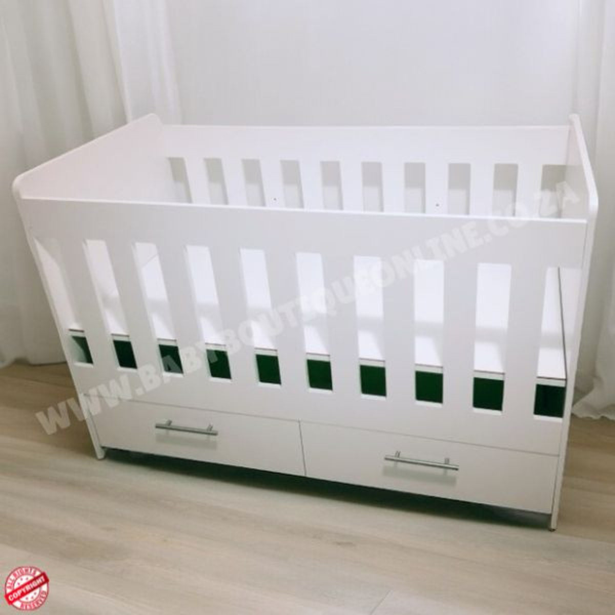 LargeWoodenCotwithSplitDrawerWhite with green accents on a wooden floor against a white curtain background