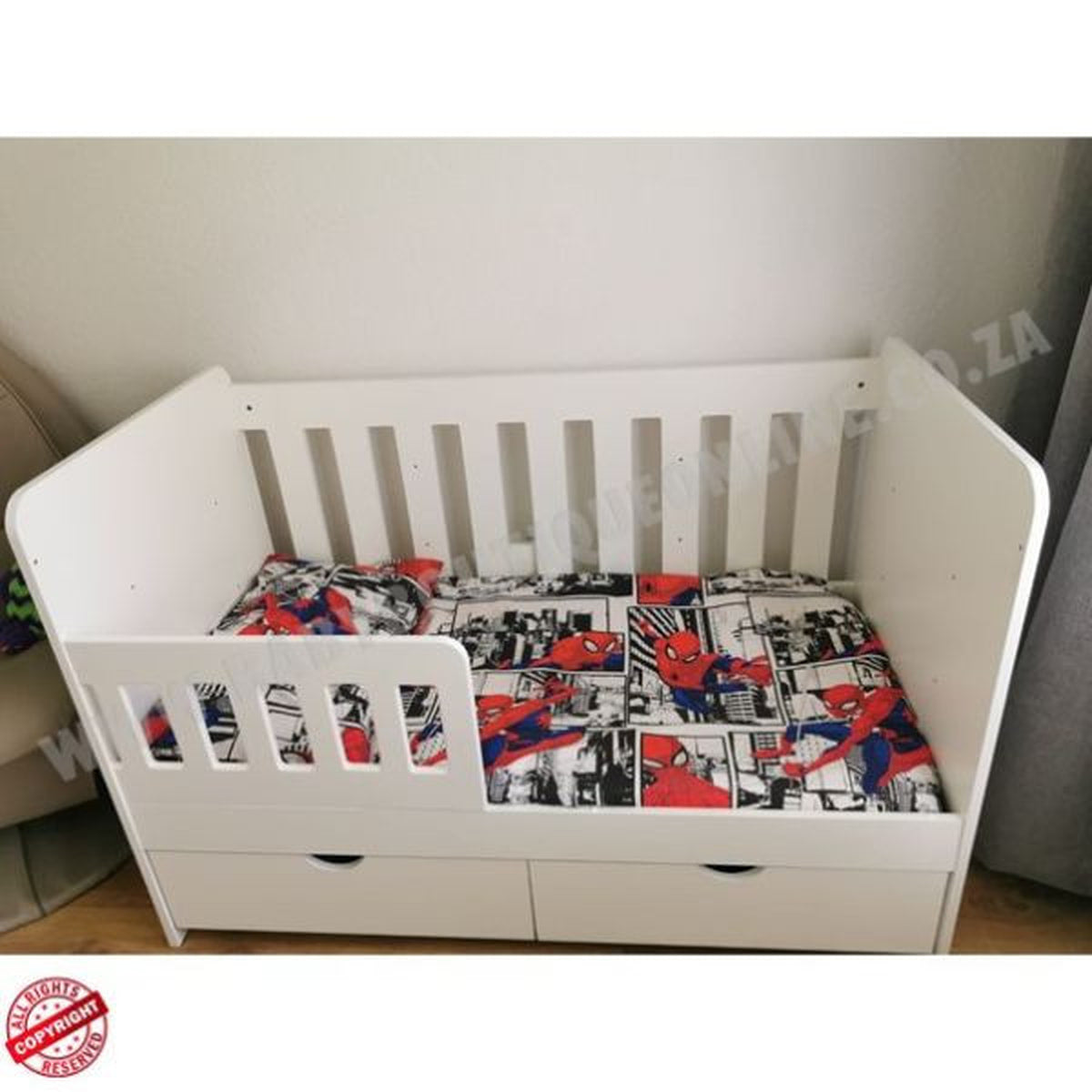 LargeWoodenCotwithSplitDrawerWhite with Spider-Man themed bedding against a plain wall.