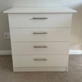 White dresser with four drawers in a room setting