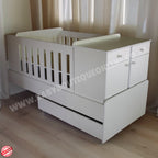 BabyBedroominaBox5-in-1Cot White baby crib with drawers in a room with curtains