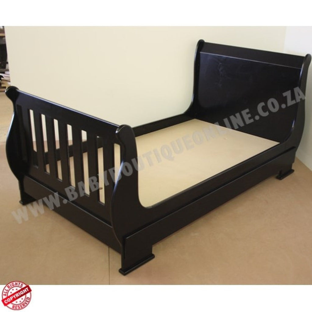 SleighCot-Convertsinto3.4Bed Black wooden crib on a beige floor with a plain background