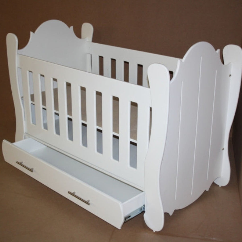 Hurricane Cot White crib with slatted design on a wooden floor with curtains in the background