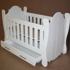 Hurricane Cot White crib with slatted design on a wooden floor with curtains in the background
