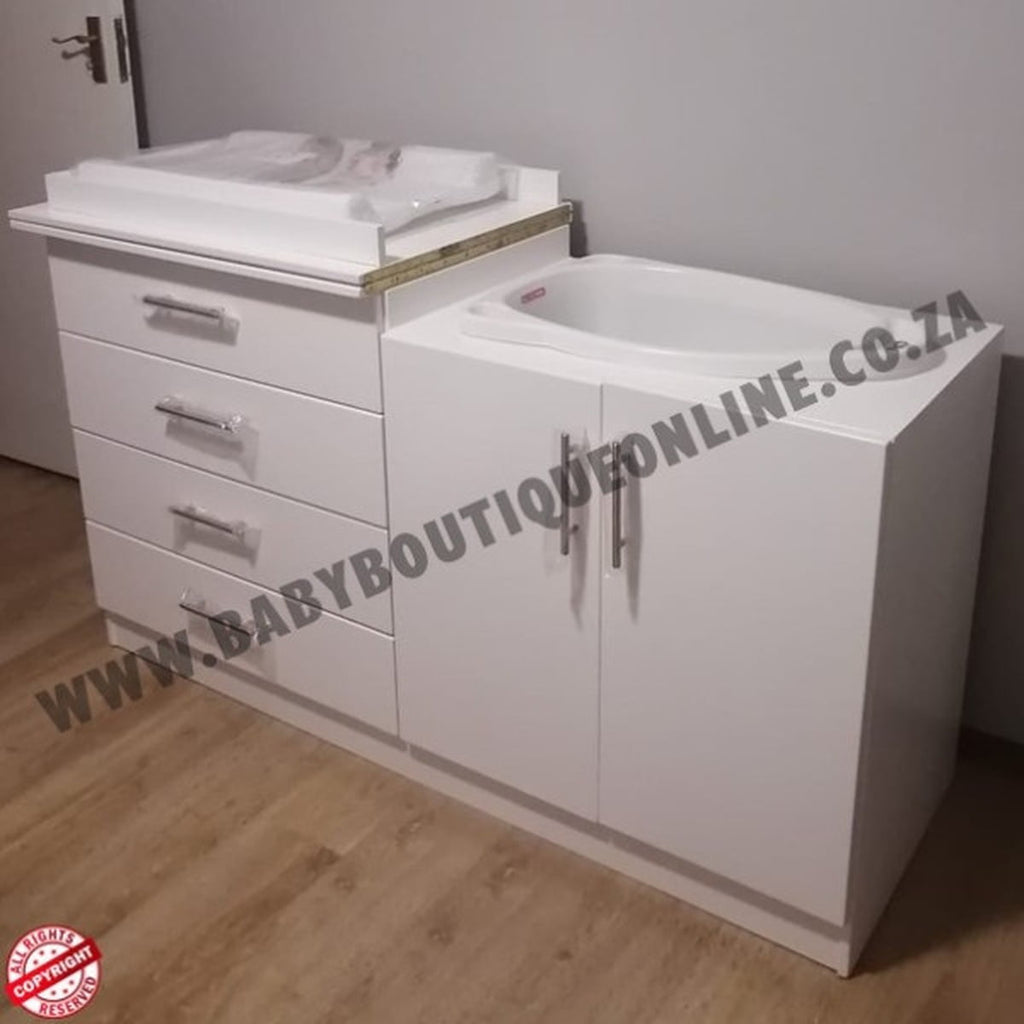 White bathroom vanity with drawers and a sink on a wooden floor.
