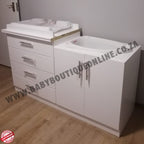 White bathroom vanity with drawers and a sink on a wooden floor.