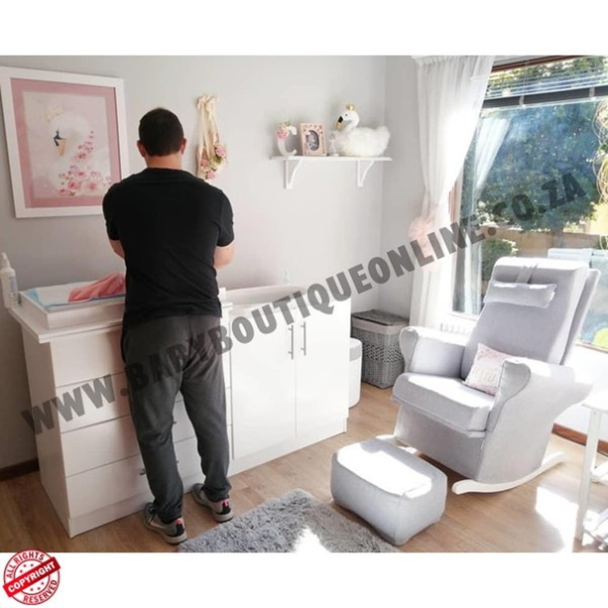 Person in a nursery room with white furniture and decor