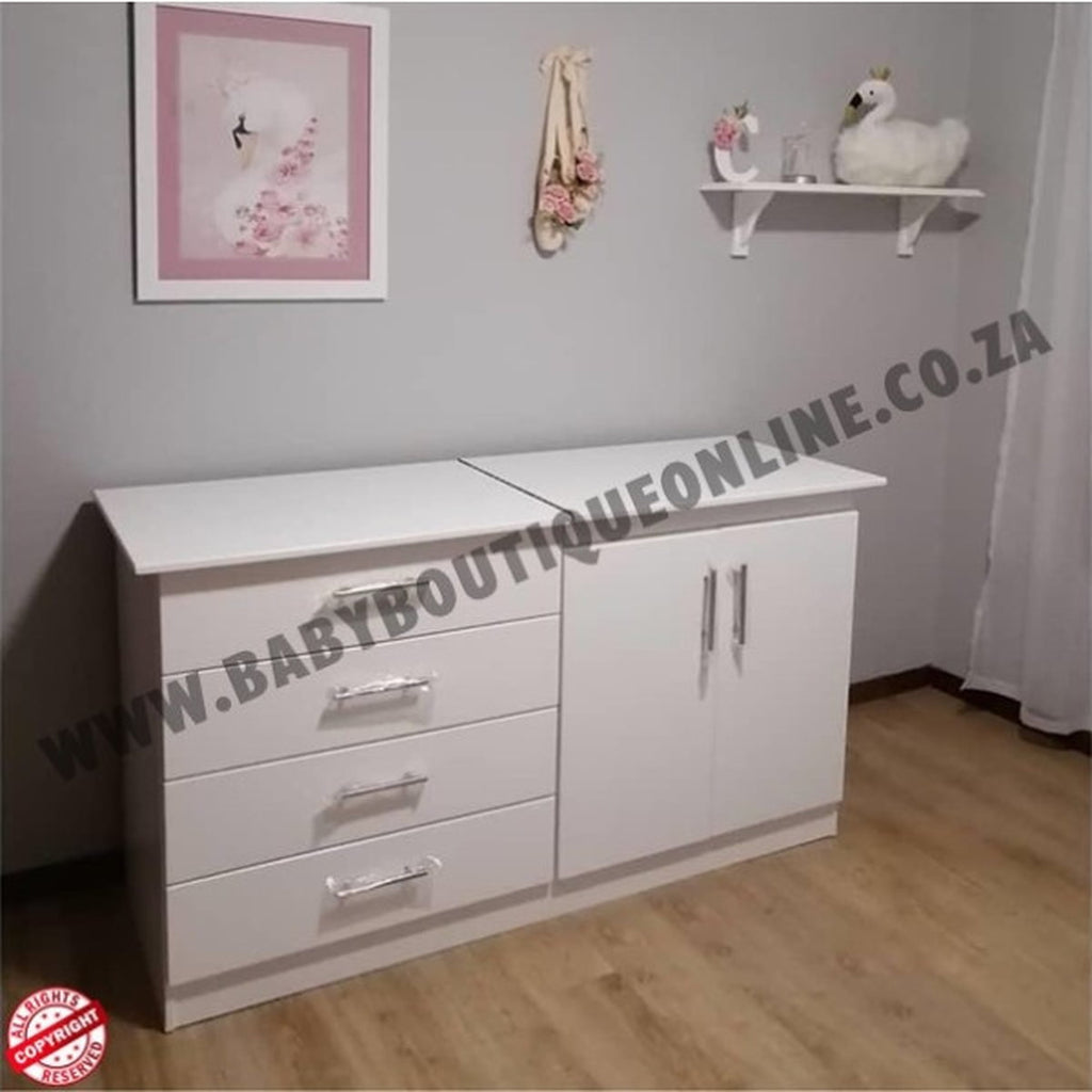 White dresser with drawers and cabinets in a room setting, featuring a decorative frame and shelf.