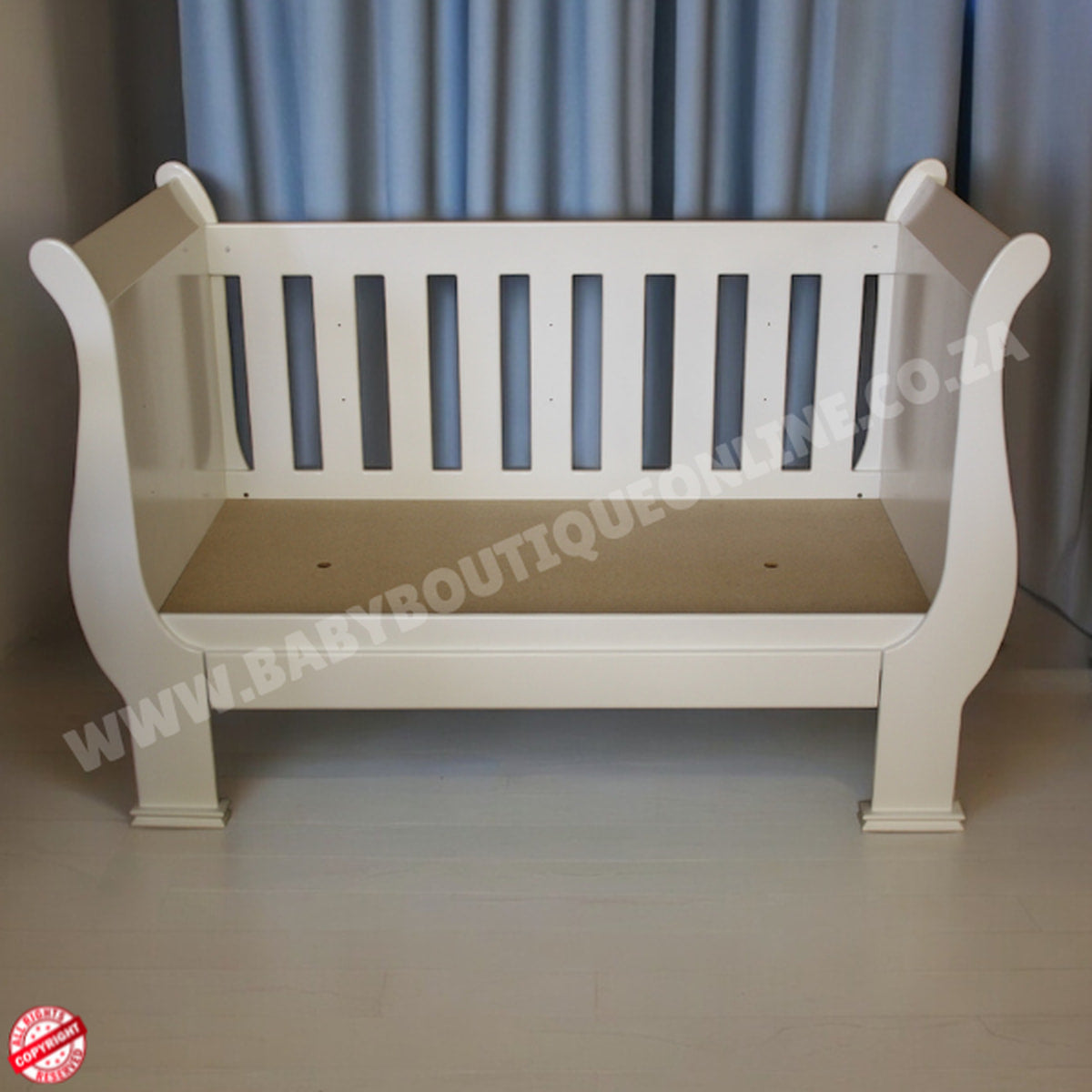 2in1 Sleigh Cot White baby crib with a beige mattress against a gray curtain background