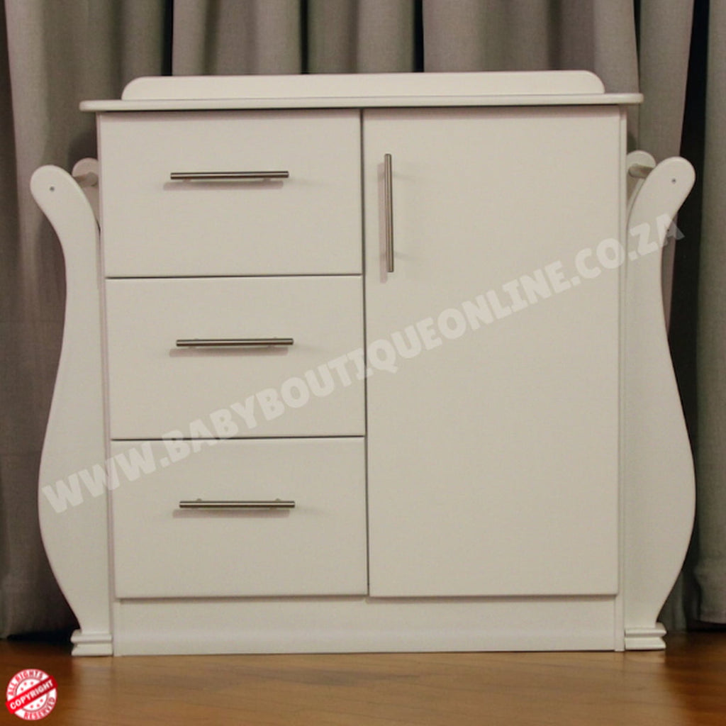 White nursery dresser with drawers and a door against a neutral background