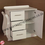White cabinet with open door and drawers on a brown background