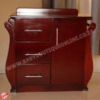 Wooden dresser with three drawers on a beige floor and wall.