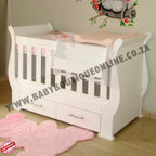 Sleigh Cot with Drawers with pink bedding in a room with a decorative wall sticker.