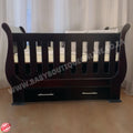 SleighCot with Drawers Burgundy with drawers against a white curtain background