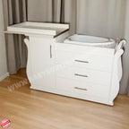 White baby changing table with drawers against a gray curtain background