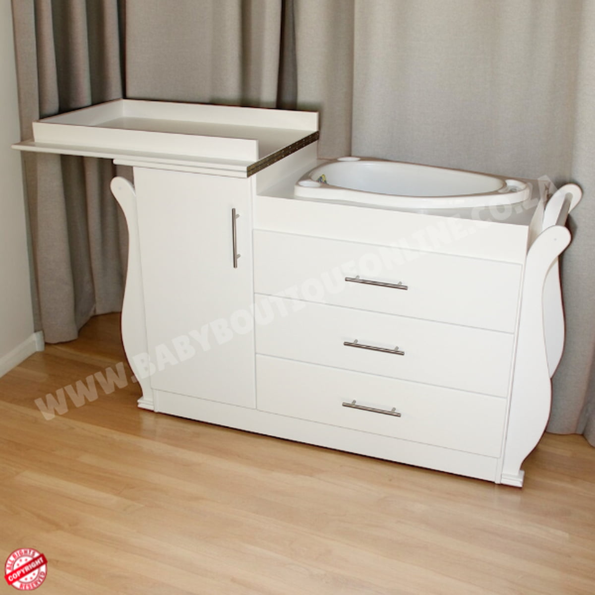 White baby changing table with drawers against a gray curtain background