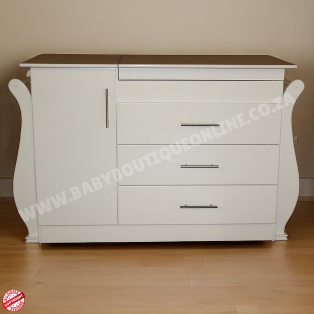 White dresser with brown top on a wooden floor against a beige wall.