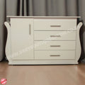 White dresser with multiple drawers against a neutral background