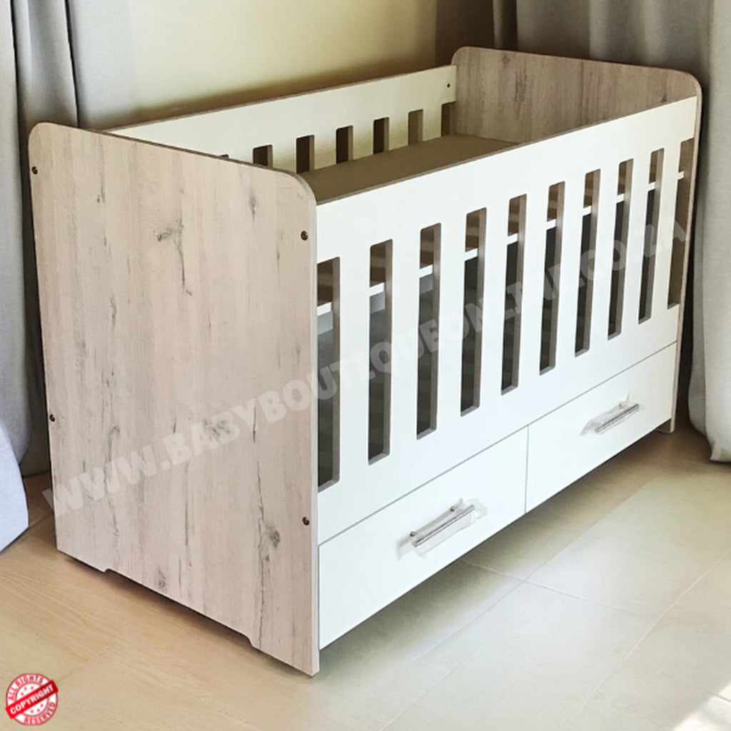Large Wooden Cot with Split Drawer White with white sides and drawers on a light wooden floor.