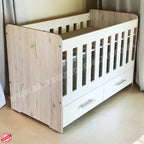 Large Wooden Cot with Split Drawer White with white sides and drawers on a light wooden floor.