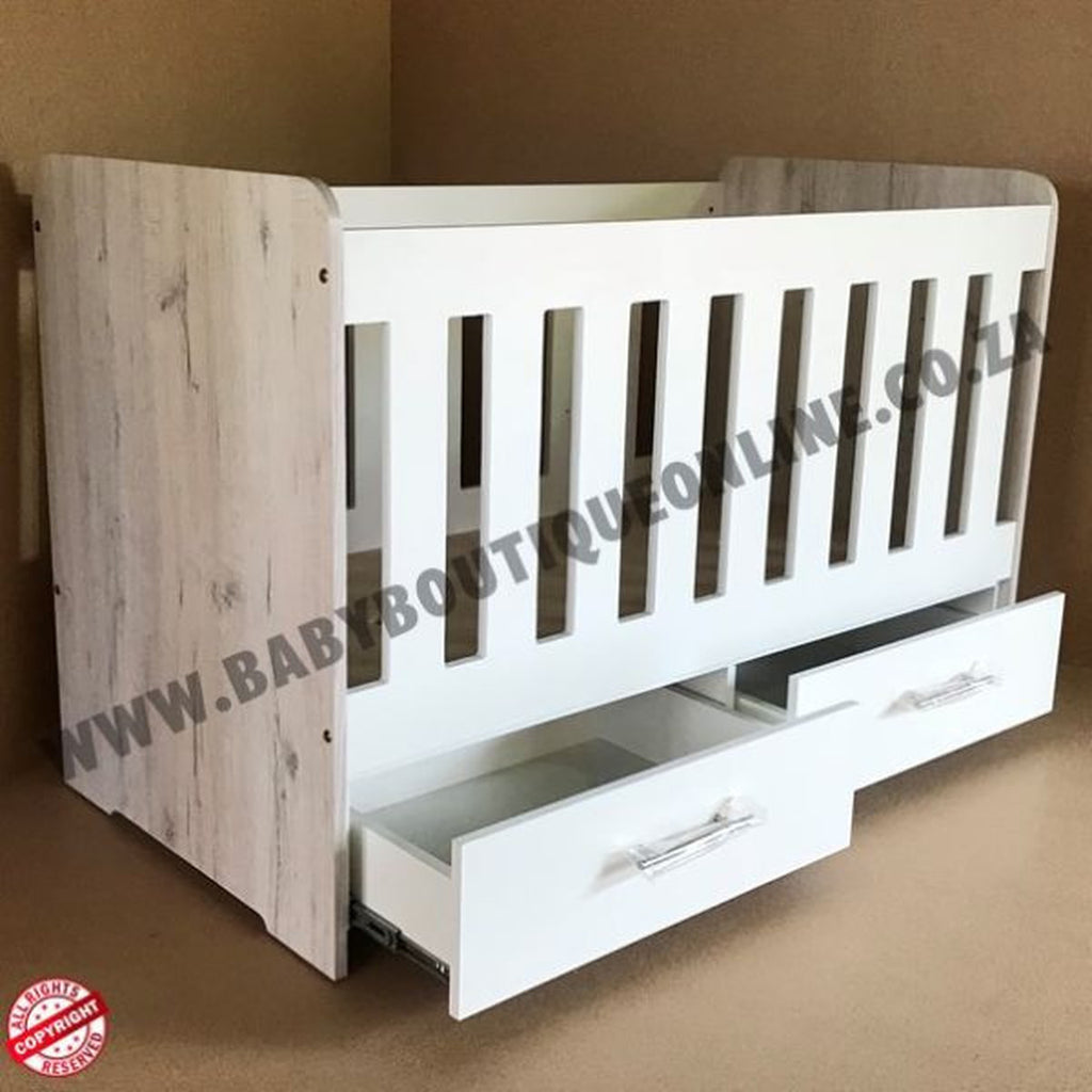 Large Wooden Cot with Split Drawer White with white sides and drawers on a light wooden floor.