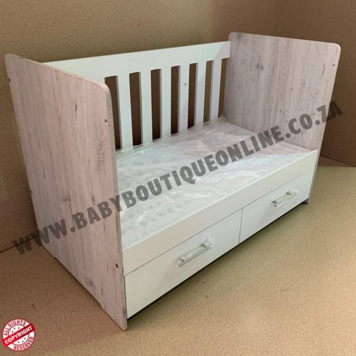 Large Wooden Cot with Split Drawer White with white sides and drawers on a light wooden floor.