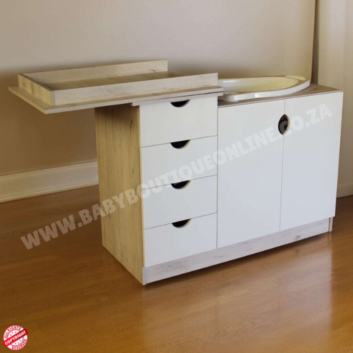 Baby changing table with wooden top and white cabinet on a wooden floor.