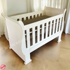 3-in-1 Sleigh Cot and Co-Sleeper White baby crib on a wooden floor with white curtains in the background