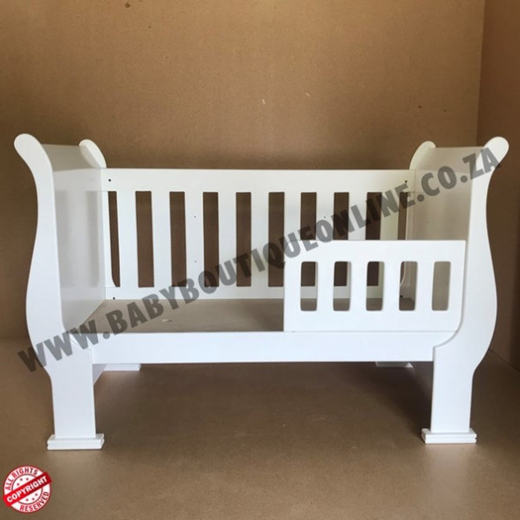 3-in-1 Sleigh Cot and Co-Sleeper White baby crib on a wooden floor with white curtains in the background 