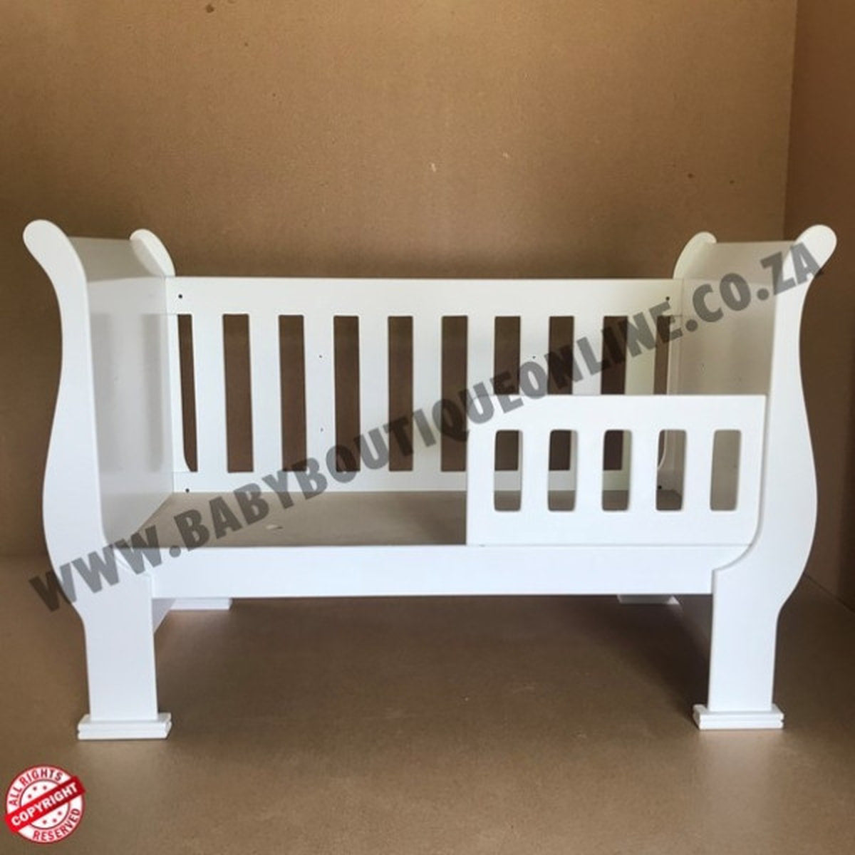 3-in-1 Sleigh Cot and Co-Sleeper White baby crib on a wooden floor with white curtains in the background 
