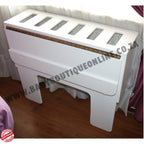 White baby co sleeper with glass panels on a wooden floor.