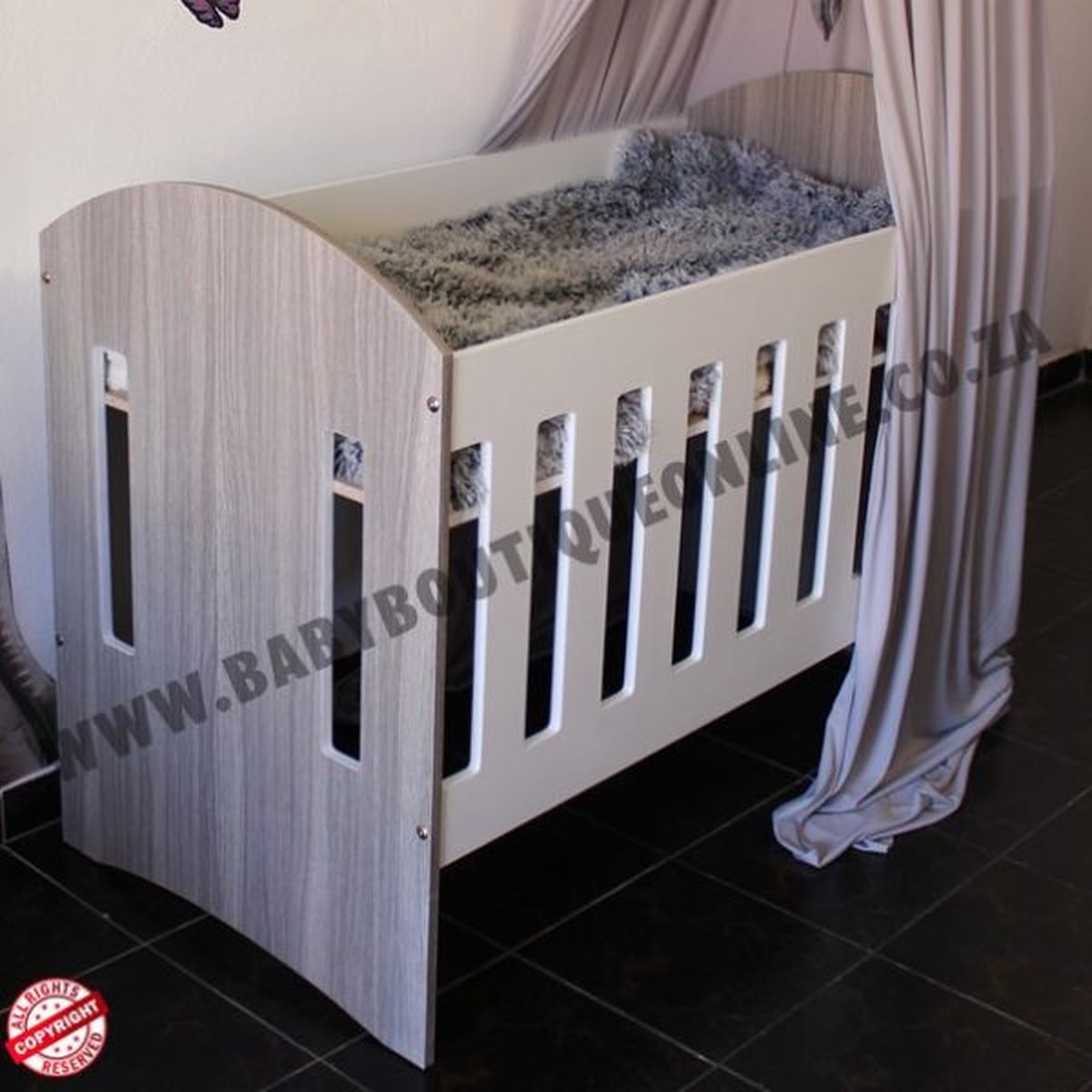 Large Wooden Cot-Round Sides Wooden crib with a canopy in a room setting, featuring a brand logo.