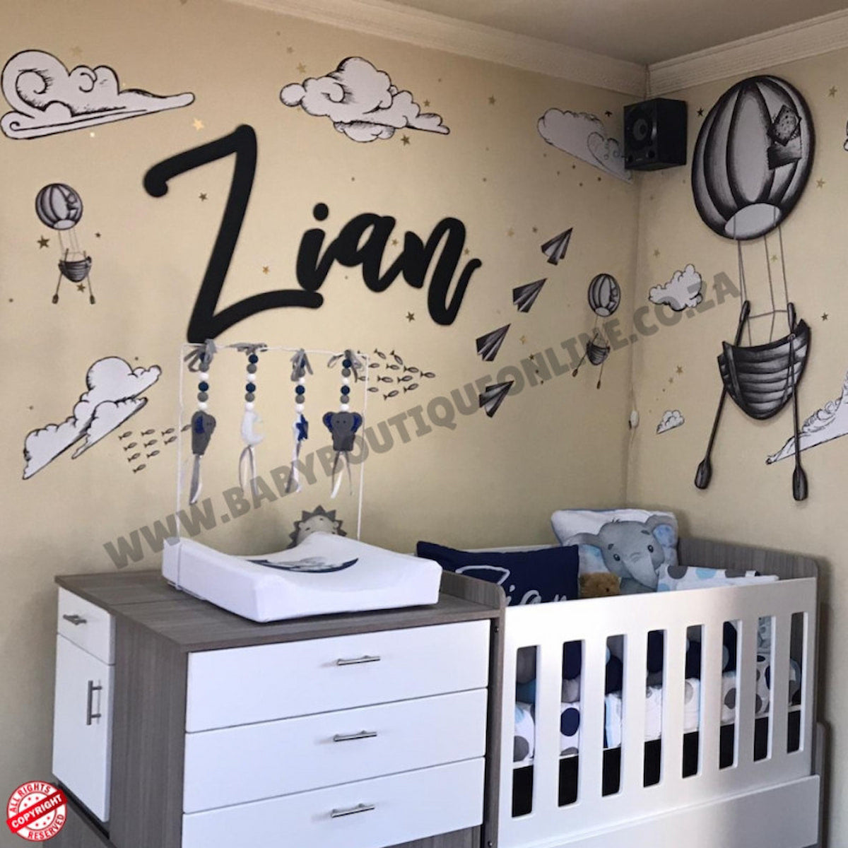 Children's room with bedroom in a box  crib, changing table, and wall decorations including the name 'Zian'.