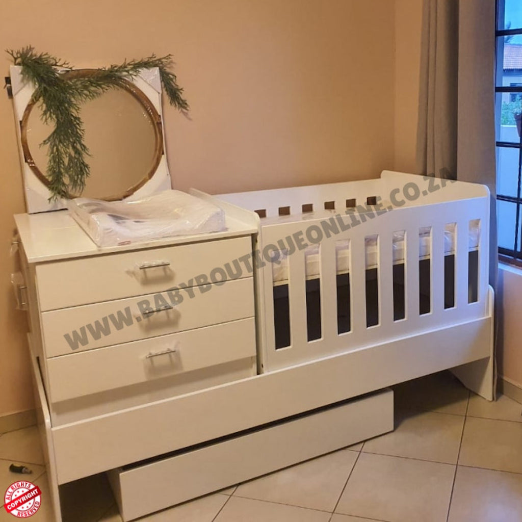 Babybedroominabox5-in-1Cot White crib and changing table set in a room with decorative elements.