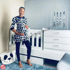Babybedroominabox5-in-1Cot Woman standing in a nursery room with white furniture and decor.