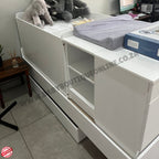 White storage unit with shelves and a drawer in a room setting.