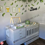 Nursery room with white crib, changing table, and decor elements.