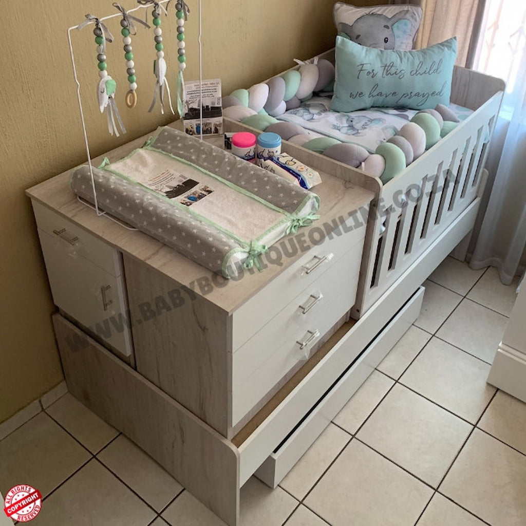 Baby crib with changing table and baby items in a nursery setting