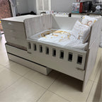White crib with wooden accents in a room setting