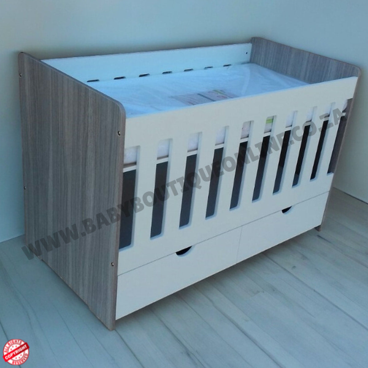 LargeWoodenCotwithSplitDrawerWhite_Cascade with wooden side and white top, on a light wooden floor.