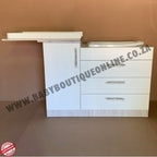 White vanity unit with drawers against a brown background, featuring 'www.babyboutiqueonline.co.za' text.