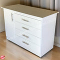 White dresser with silver handles on a wooden floor.