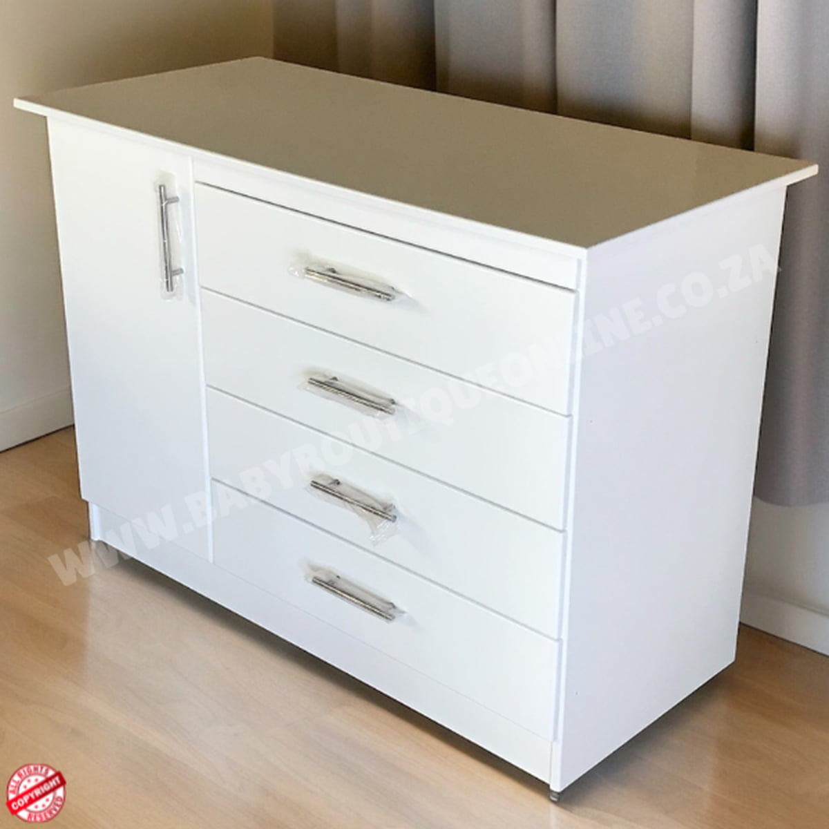 White dresser with silver handles on a wooden floor.
