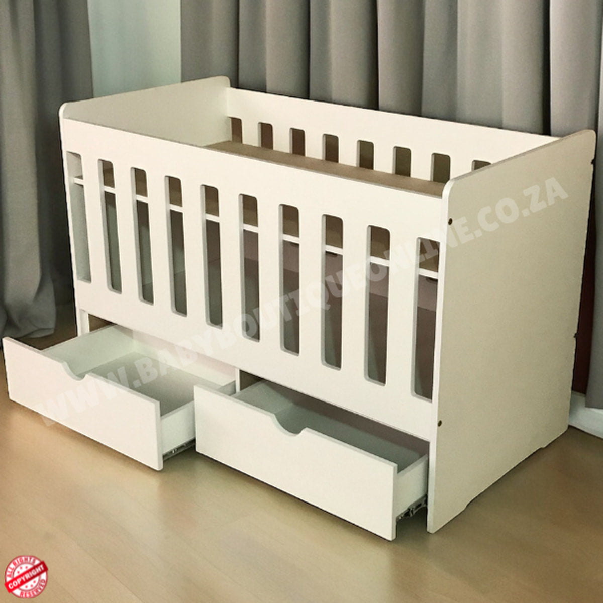 Large Wooden Cot with split Drawer-HalfMoonWhite crib with drawers open on a wooden floor with gray curtains in the background