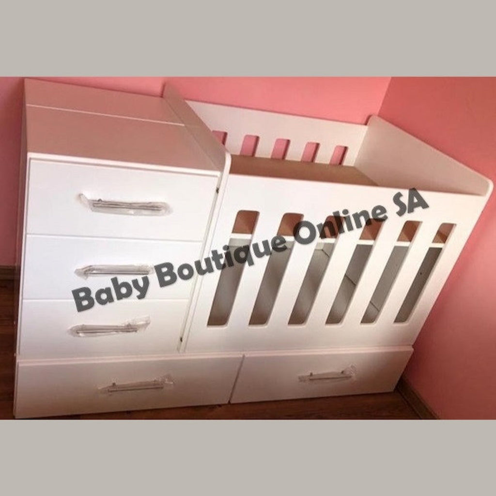 BabyBedroominaBox4-in-1 White baby crib with drawers against a pink wall, branded 'Baby Boutique Online SA'.