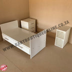 White children's bed with two side tables on a brown floor, with 'BabyBoutiqueOnline.co.za' branding.