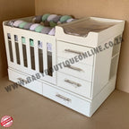 BabyBedroominaBox4-in-1 White baby changing table with drawers and a crib on a brown background