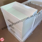 BabyBedroominabox4-in-1 White baby changing table with drawers on a brown surface, branded 'Baby Boutique Online'.