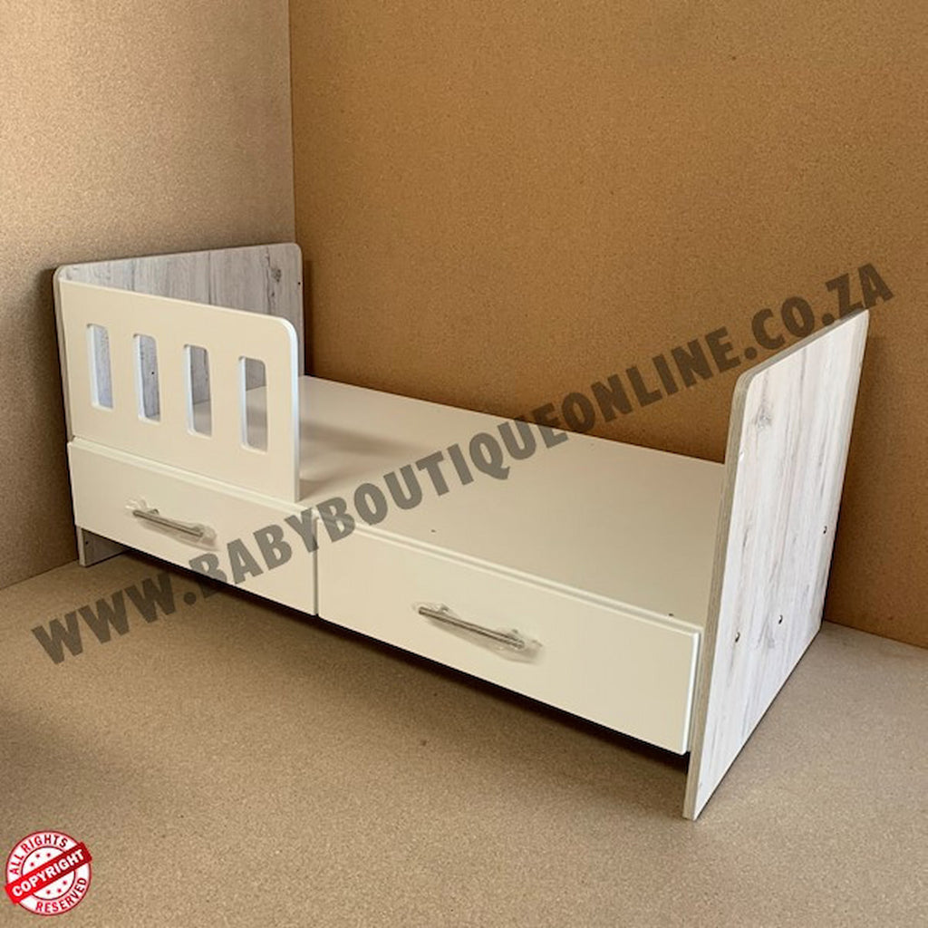 White children's bed with drawers against a brown wall, branded 'Babyboutiqueonline.co.za'.